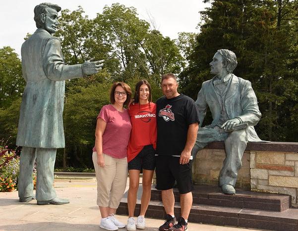 A family poses for a portrait in front of the Lincoln statue.
